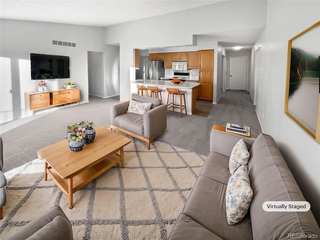 carpeted living room with lofted ceiling