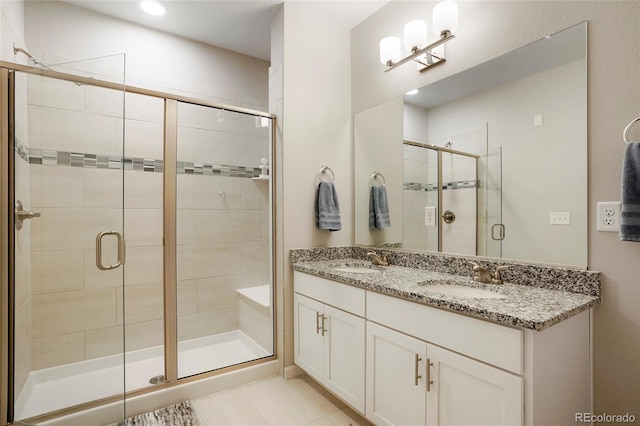 bathroom featuring a shower with door, vanity, and tile patterned floors