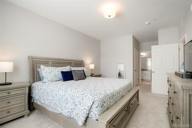 carpeted bedroom featuring ensuite bath