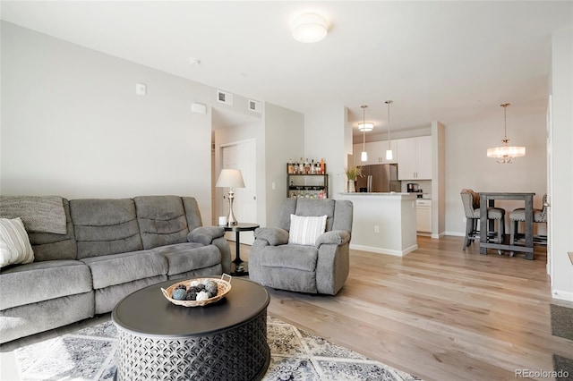 15700 E Jamison Dr Unit 8-103, Englewood, CO 80112 - living room featuring light wood-type flooring and a chandelier