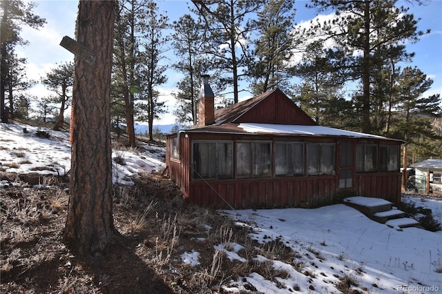 snow covered property with a sunroom