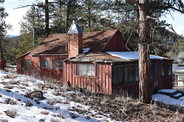 view of snowy exterior featuring a sunroom