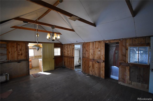 interior space featuring vaulted ceiling with beams, an inviting chandelier, dark wood-type flooring, and wood walls