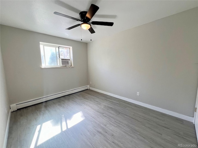 spare room featuring baseboard heating, ceiling fan, wood-type flooring, and cooling unit