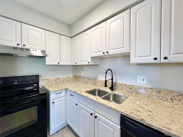 kitchen featuring light stone countertops, white cabinetry, sink, and black appliances