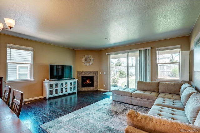 15619 Syracuse Way, Thornton, CO 80602 - living area with dark wood finished floors, a textured ceiling, and a lit fireplace