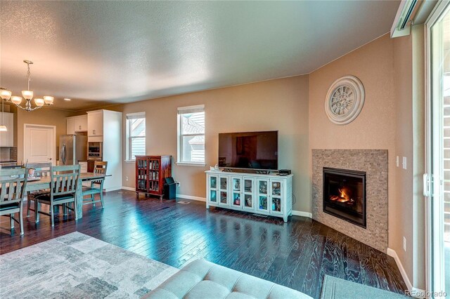 15619 Syracuse Way, Thornton, CO 80602 - living room featuring a chandelier, dark wood-style floors, and a tiled fireplace