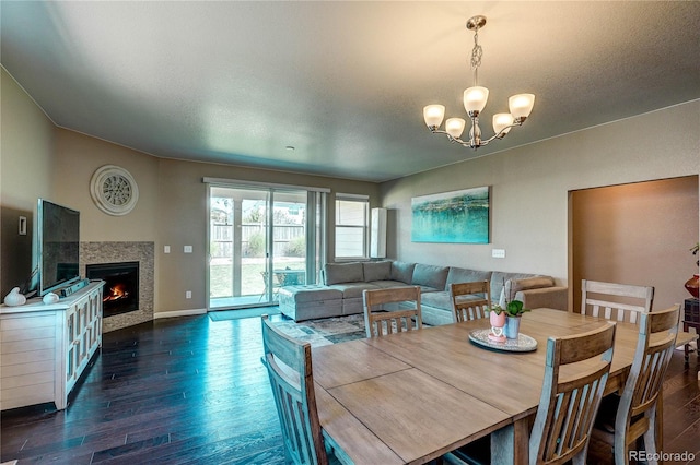 15619 Syracuse Way, Thornton, CO 80602 - dining space with wood finished floors, a chandelier, and a tiled fireplace