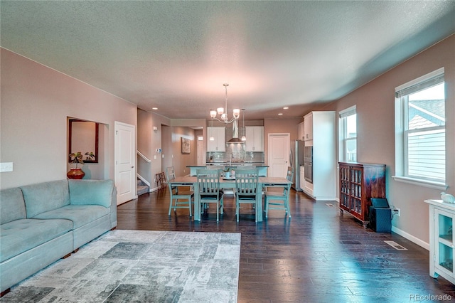 15619 Syracuse Way, Thornton, CO 80602 - dining space with a chandelier, dark wood-type flooring, stairs, recessed lighting, and a textured ceiling
