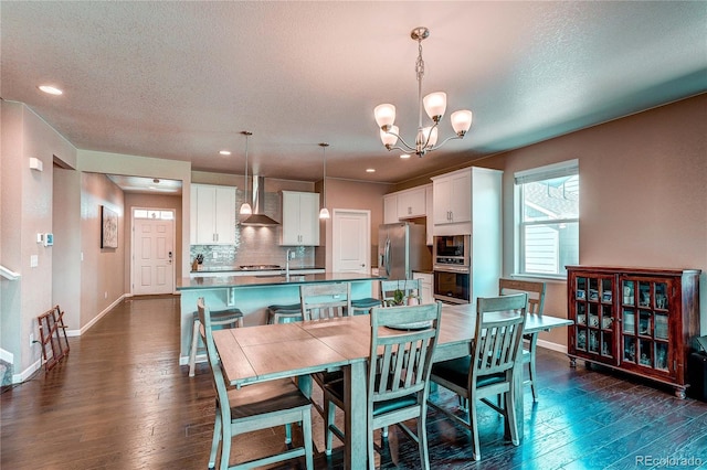 15619 Syracuse Way, Thornton, CO 80602 - dining space featuring a chandelier, dark wood-style floors, a textured ceiling, and recessed lighting
