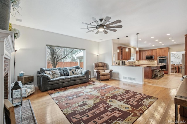 living area featuring light wood-style floors, visible vents, a ceiling fan, and recessed lighting