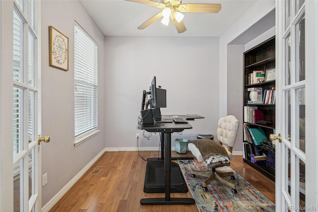 home office featuring light wood-style floors, ceiling fan, baseboards, and french doors