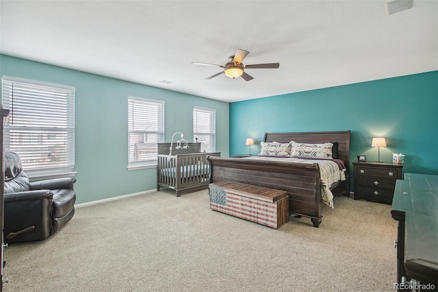 bedroom with light carpet, visible vents, baseboards, and a ceiling fan