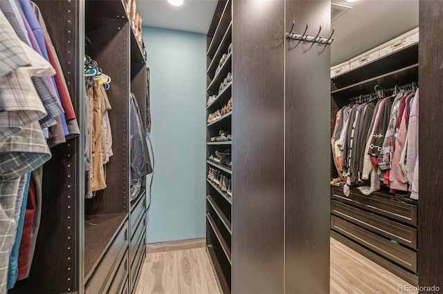 walk in closet with light wood-type flooring