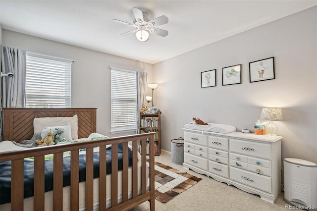 bedroom featuring light carpet and a ceiling fan