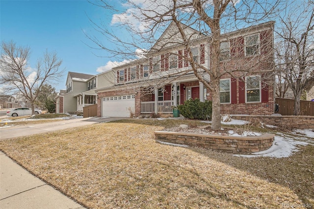 view of front of house featuring driveway, covered porch, an attached garage, and brick siding