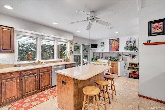 kitchen featuring a center island, a breakfast bar, dishwasher, and light tile patterned floors