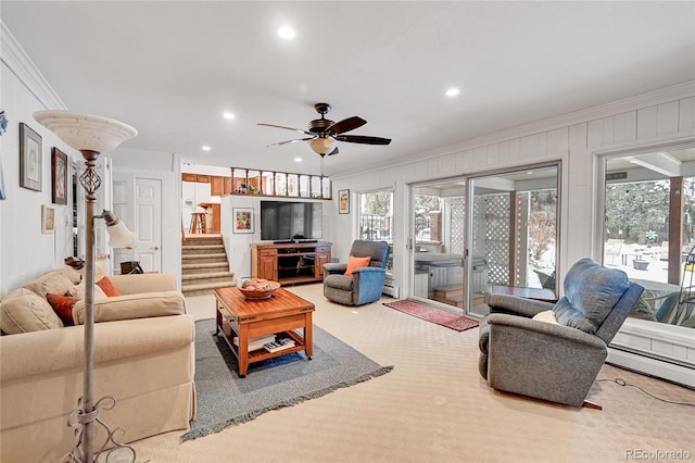 carpeted living room featuring a baseboard radiator, ceiling fan, and crown molding