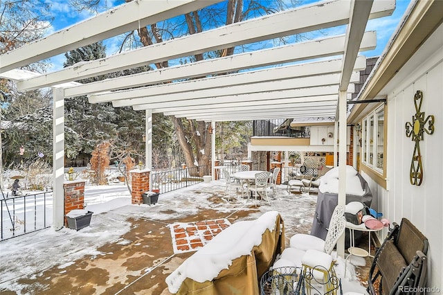 snow covered patio with a pergola