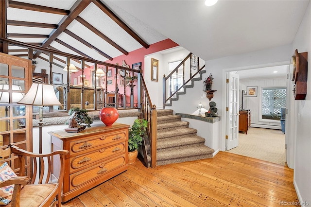 stairs featuring lofted ceiling with beams, a baseboard radiator, and hardwood / wood-style floors