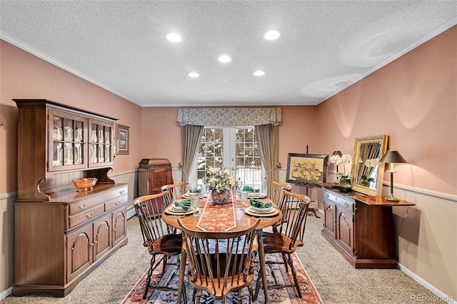 dining area featuring crown molding, light colored carpet, a textured ceiling, and french doors