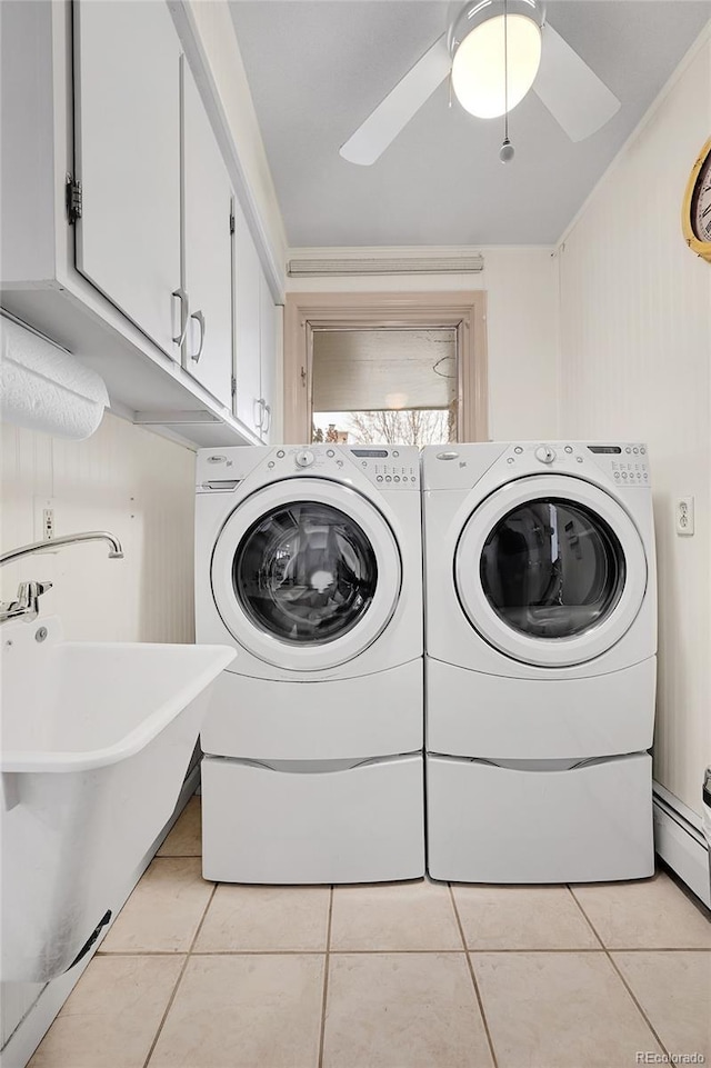 laundry room featuring cabinets, a baseboard heating unit, light tile patterned floors, ceiling fan, and washer and clothes dryer