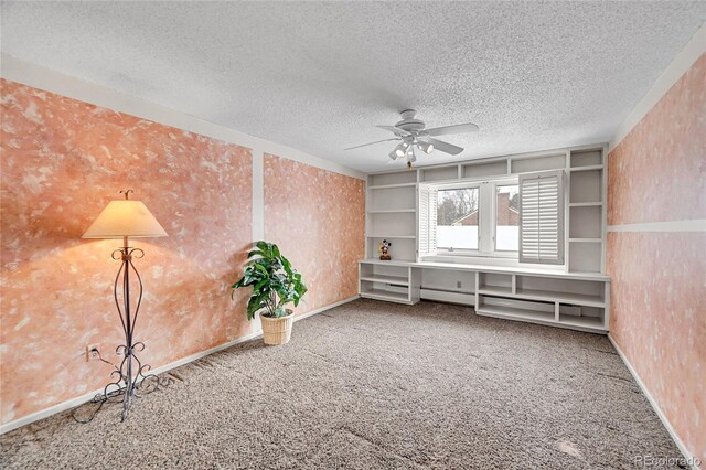 interior space featuring ceiling fan, carpet flooring, built in features, and a textured ceiling