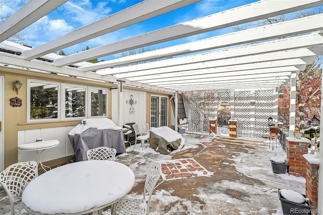 snow covered patio featuring area for grilling and a pergola