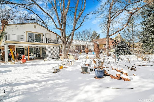 yard layered in snow featuring a balcony