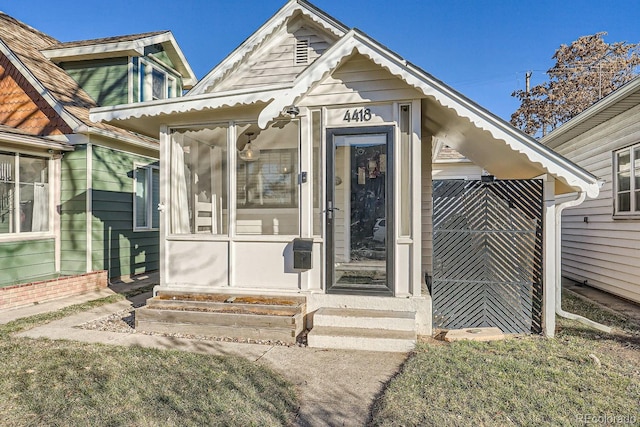 view of exterior entry featuring a lawn