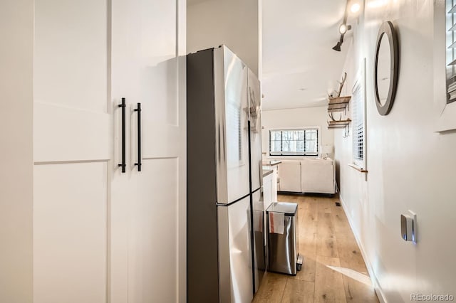 kitchen featuring light wood-style floors, freestanding refrigerator, and white cabinets