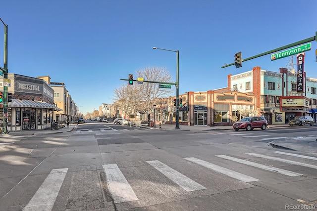 view of street featuring street lighting, traffic lights, curbs, and sidewalks