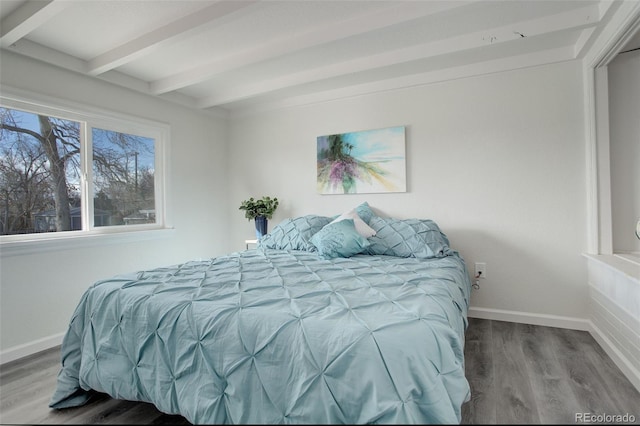 bedroom with hardwood / wood-style floors and beam ceiling