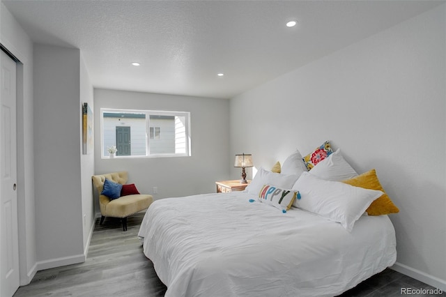 bedroom featuring hardwood / wood-style flooring and a textured ceiling