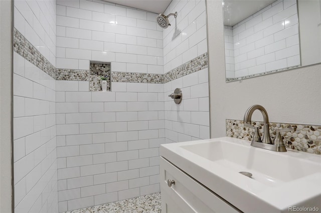 bathroom with vanity and a tile shower