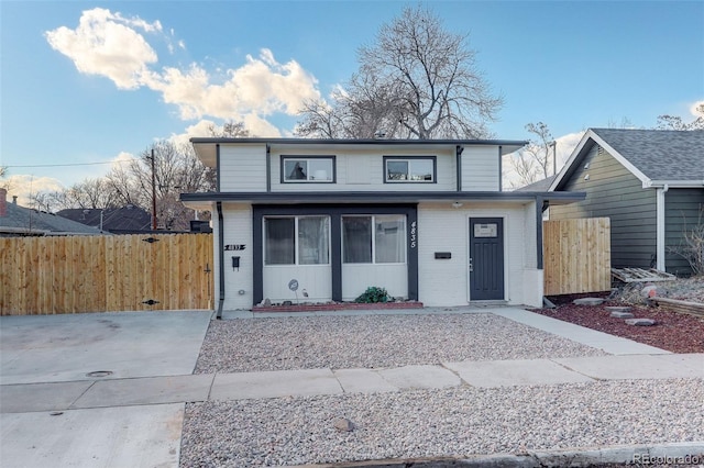 view of front of property with a gate, fence, and brick siding
