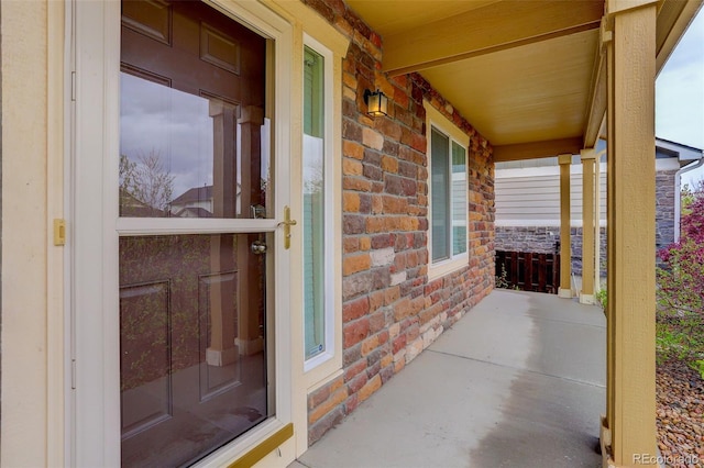 25812 E Cedar Pl, Aurora, CO 80018 - doorway to property featuring covered porch, stone siding, and brick siding