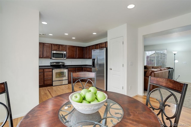 25812 E Cedar Pl, Aurora, CO 80018 - kitchen featuring stainless steel appliances, light wood-style flooring, recessed lighting, dark countertops, and dark brown cabinetry