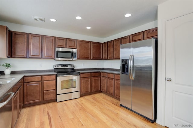 25812 E Cedar Pl, Aurora, CO 80018 - kitchen with stainless steel appliances, recessed lighting, light wood-style floors, a sink, and dark countertops