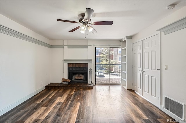 unfurnished living room with ceiling fan, visible vents, a brick fireplace, wood finished floors, and baseboards