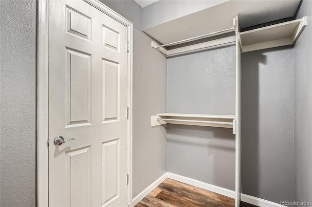 walk in closet with wood finished floors