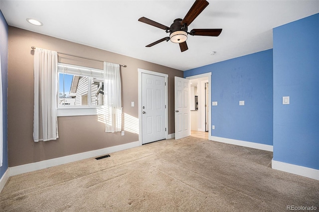 empty room featuring ceiling fan and carpet