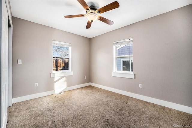 unfurnished room with ceiling fan and carpet flooring