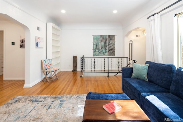 1661 Oneida St, Denver, CO 80220 - living area with arched walkways, wood finished floors, recessed lighting, and built in shelves