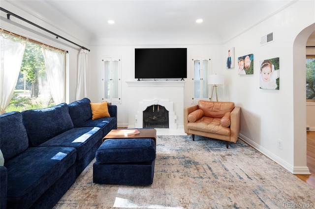 1661 Oneida St, Denver, CO 80220 - living area featuring arched walkways, healthy amount of natural light, a fireplace, wood finished floors, and recessed lighting