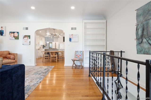 1661 Oneida St, Denver, CO 80220 - hallway featuring arched walkways, light wood-style floors, an upstairs landing, recessed lighting, and a chandelier