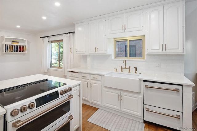 1661 Oneida St, Denver, CO 80220 - kitchen featuring double oven range, light countertops, recessed lighting, backsplash, and white cabinetry