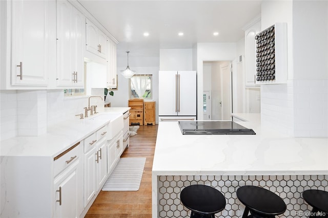1661 Oneida St, Denver, CO 80220 - kitchen featuring white appliances, a peninsula, white cabinetry, backsplash, and recessed lighting