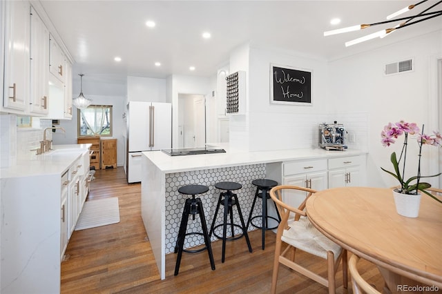1661 Oneida St, Denver, CO 80220 - kitchen with freestanding refrigerator, a peninsula, light wood-type flooring, tasteful backsplash, and recessed lighting