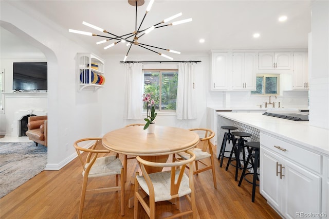 1661 Oneida St, Denver, CO 80220 - dining area with light wood-style flooring, recessed lighting, a chandelier, and arched walkways